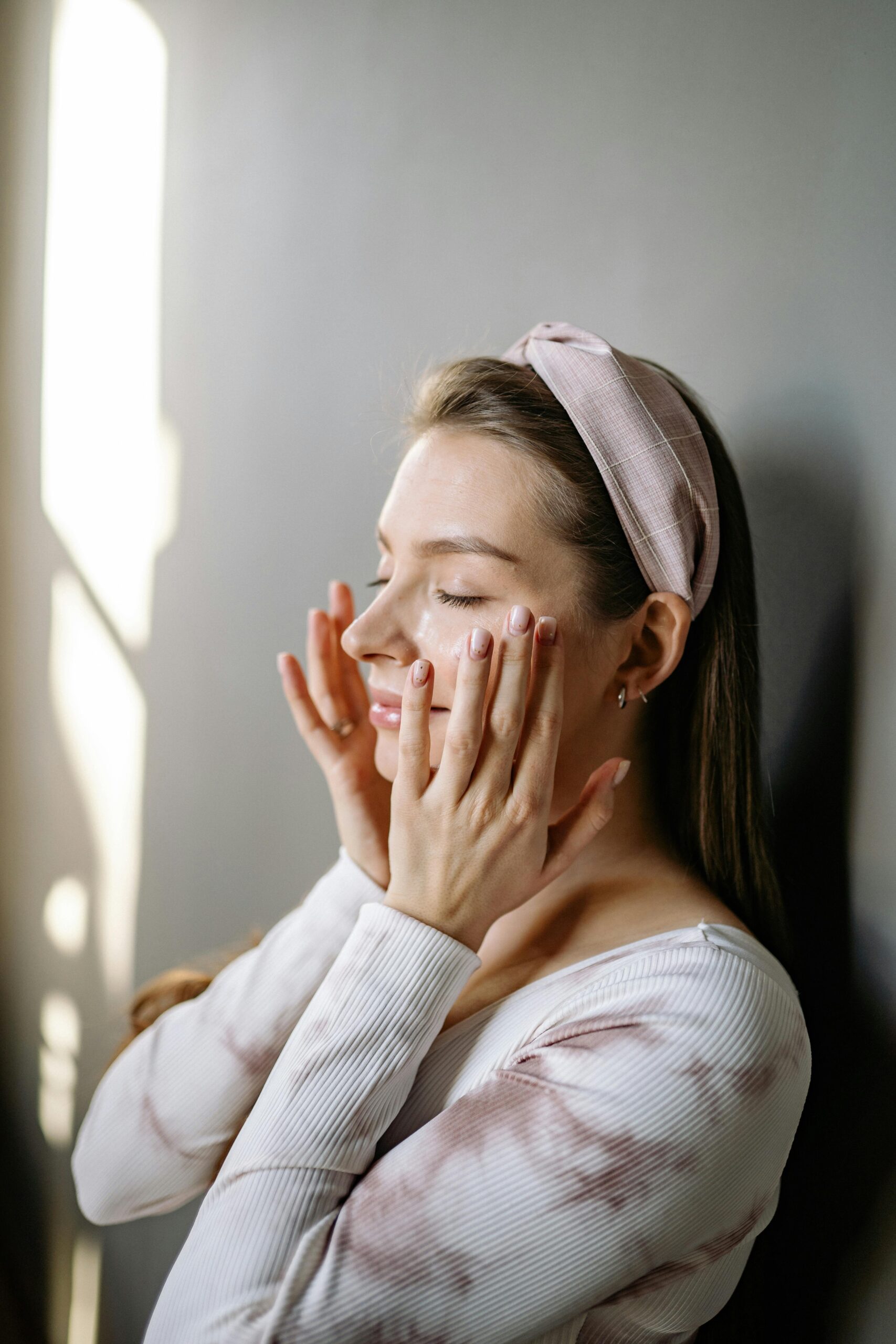 “Woman applying skincare cream on face for dry skin hydration routine